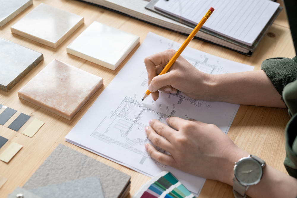 personne dessinant sur un papier une conception d'un agencement de bureau